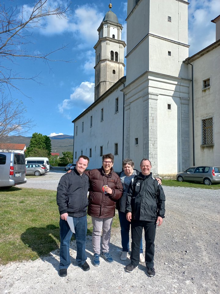 Štirje uporabniki so slikani na prostem, pred cerkvijo