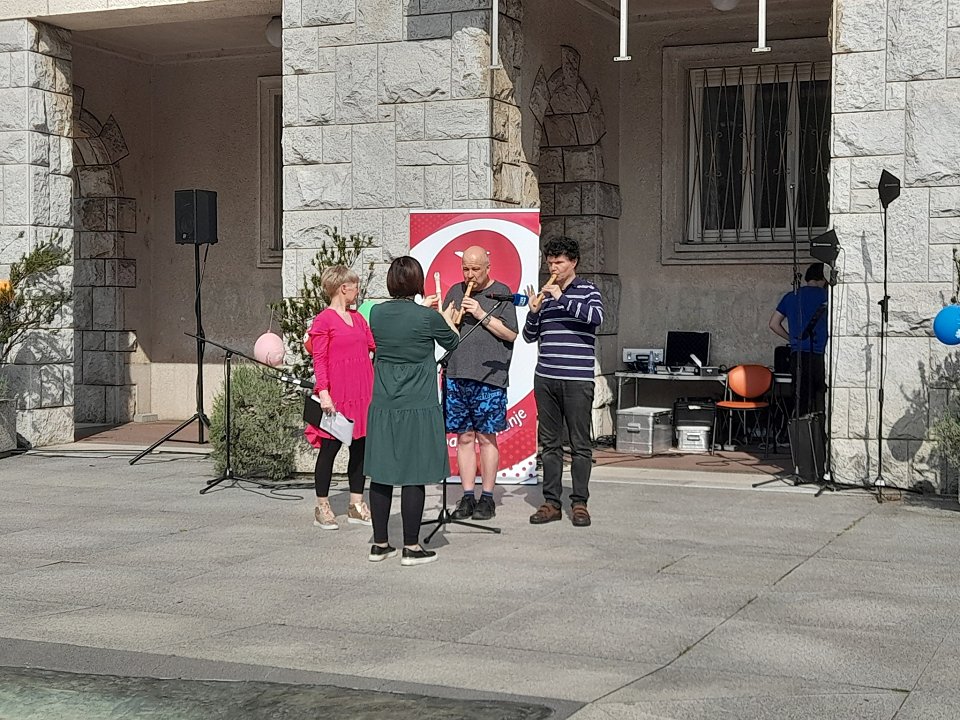 Duo flavtistov skupaj z mentorico nastopa pred občinsko stavbo v Novi Gorici