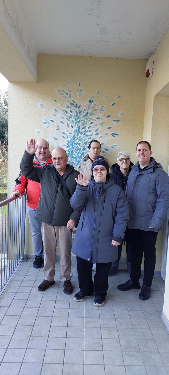 Skupina uporabnikov stoji pred stenskim muralom